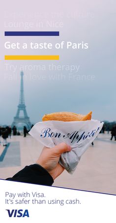 a person holding up a bag with food in front of the eiffel tower