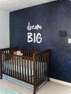 a baby's room with a crib and stars painted on the wall behind it