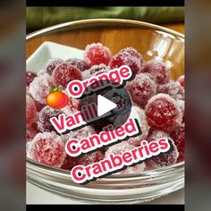 a bowl filled with oranges and cranberries on top of a table