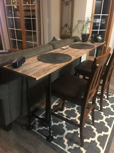 a living room with a couch, table and chairs next to a rug on the floor