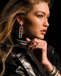 a woman in black leather jacket and earrings