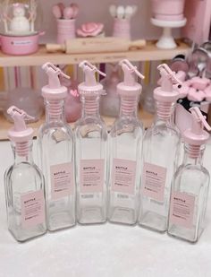 several bottles with pink labels on them sitting on a table