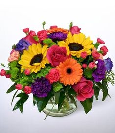 a vase filled with lots of colorful flowers