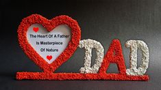 the word dad is made out of red and white yarn with a heart shaped frame