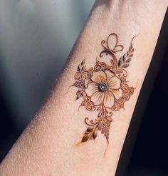 a woman's arm with a flower tattoo on it