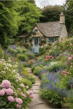 a garden with flowers and a house in the background that is surrounded by greenery