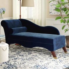 a blue velvet chaise lounge chair in a living room