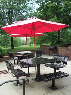 a table with an umbrella and some benches