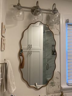 a bathroom with a sink, mirror and lights