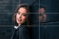 a woman leaning against a brick wall with her head on the wall and another man's face in the background