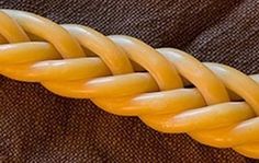 a close up of a yellow braid on a brown cloth