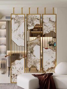 a room divider with marble and gold accents in an elegant living room setting, along with a white couch