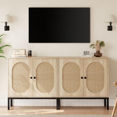 a living room with a television mounted on the wall and wicker furniture in front of it