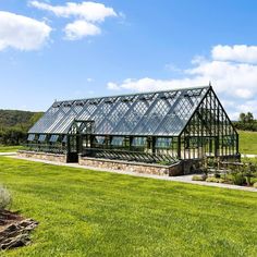 a large glass house sitting on top of a lush green field