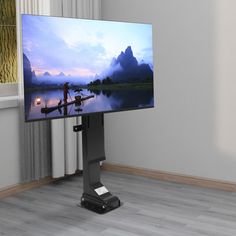 a flat screen tv sitting on top of a wooden floor in front of a window