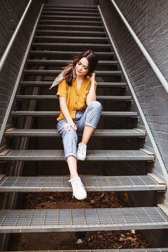 a woman sitting on top of a set of stairs