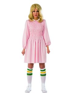 a woman in a pink dress and green striped socks is standing with her hands on her hips