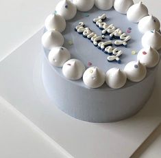 a blue birthday cake with white frosting and sprinkles