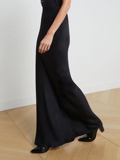 A stunning, understated maxi skirt in pure black. Bias-cut, silk-like fabric falls in a subtle, lustrous cling over the figure, enhancing and elongating the silhouette. Smooth elastic waist with no closures. | L'AGENCE Zeta Maxi Skirt In Black Full Length Satin Finish Maxi Dress, Classic Maxi Skirt For Evening, Silk Floor-length Bias Cut Maxi Skirt, Silk Bias Cut Floor-length Maxi Skirt, Silk Bias-cut Floor-length Maxi Skirt, Elegant Wide Leg Satin Maxi Skirt, Classic Flowy Maxi Skirt For Evening, Elegant Satin Maxi Skirt With Bias Cut, Elegant Satin Bias Cut Maxi Skirt