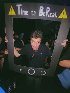 a young man is posing in front of a photo frame that says time to be real