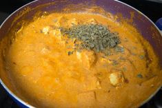 a pan filled with food sitting on top of a stove next to a blue container