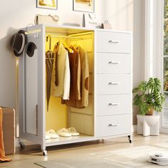 an open white cabinet with clothes hanging on it