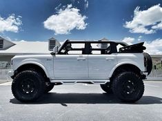 a white truck parked in front of a house on a sunny day with blue sky and clouds