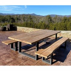 a wooden picnic table sitting on top of a stone patio