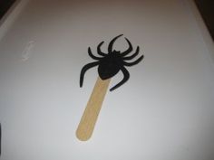 a wooden stick with a spider on it sitting on top of a white laptop computer