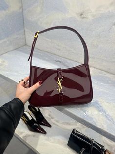 a woman's hand holding onto a red purse