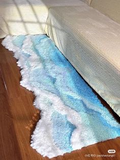 a bed sitting on top of a wooden floor next to a rug