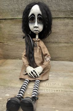 a creepy doll sitting on top of a wooden bench