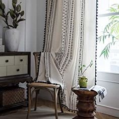 a chair sitting in front of a window next to a table with a potted plant on it