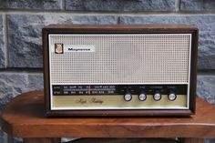 an old fashioned radio sitting on top of a wooden table next to a brick wall