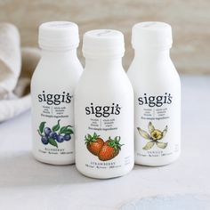 three bottles of siggis are sitting on a table