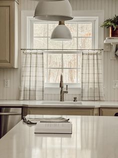 a kitchen with a book on the counter and a window in the backround