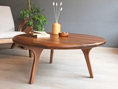 a wooden table sitting on top of a hard wood floor next to a white couch