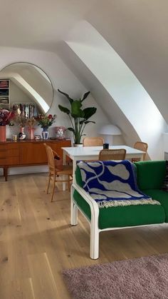 an image of a living room setting with furniture and decor on the walls, including a green couch