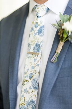 a man wearing a blue suit and floral tie