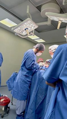 several doctors in scrubs are performing surgery