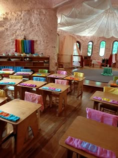 a classroom with wooden desks and chairs covered in colorful material on top of them