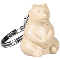 a white bear shaped keychain sitting on top of a ring