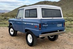 an old ford bronco is parked in the desert