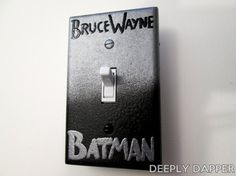 a batman light switch cover with the words bruce wayne painted on it's side