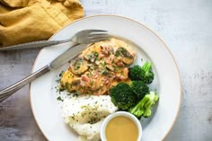 a white plate topped with meat, mashed potatoes and broccoli