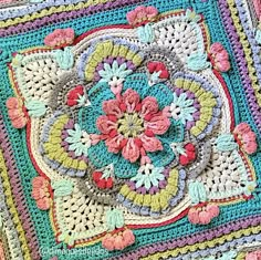 a crocheted granny blanket with flowers on it