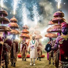 a group of people dressed in costume standing next to each other with fireworks behind them