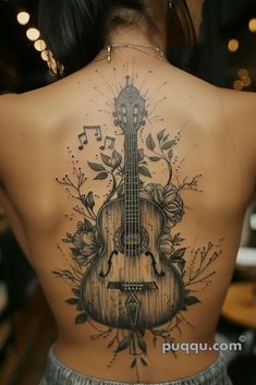 a woman with a guitar tattoo on her back