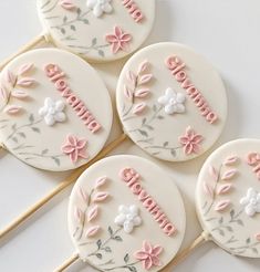 four decorated cookies sitting on top of each other in the shape of flowers and leaves