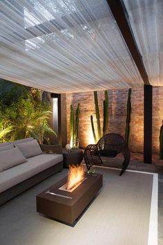 an outdoor living area with couches, tables and cacti in the background